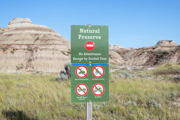 Natural Preserve sign at Dinosaur Provincial Park Shot focused on a sign at Dinosaur Provincial Park located in Alberta, Canada. Sign says 'Natural Preserve. No admittance, except by guided tour'. The Alberta badlands is well known for being one of the richest dinosaur fossil locales in the world. drumheller stock pictures, royalty-free photos & images