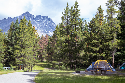 Stunning landscape shot of mountains and a camping tent in beautiful Banff Provincial Park.