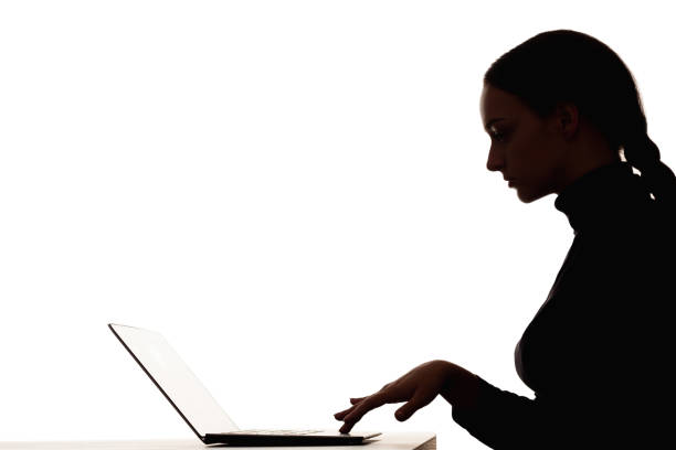 Woman silhouette. Online learning. Distance education. Dark contrast profile shape portrait of smart female student working with laptop in virtual class isolated on white empty space background.