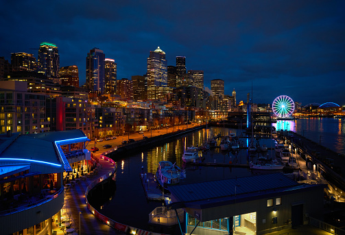 Downtown Seattle skyline at twilight. The ferris wheel stands out along the shoreline. Washington State, USA.
