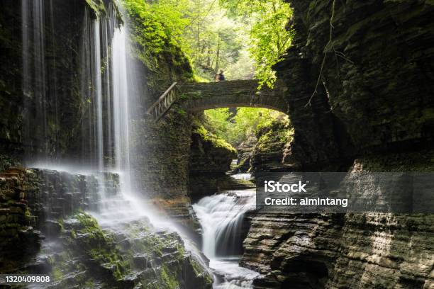 Rainbow Falls With A Lady On Bridge At Watkins Glen State Park Stock Photo - Download Image Now