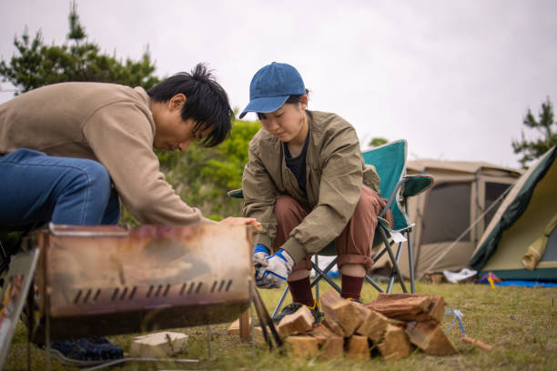 istock Young woman cutting firewood at camp 1320411565