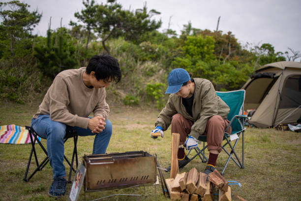 istock Young woman cutting firewood at camp 1320411666