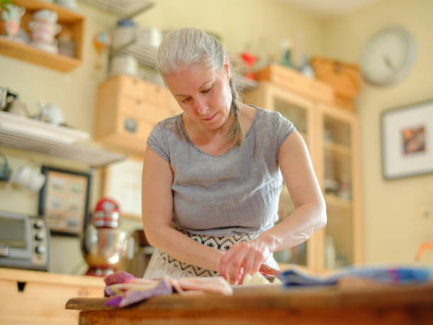 istock Mature woman preparing Nicoise Salad 1320415967