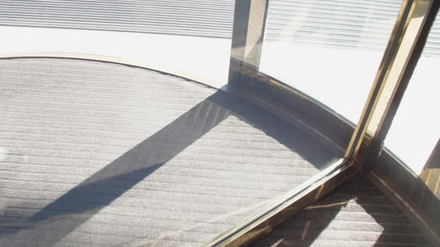 Sunlight reflects in mechanical revolving door in hotel