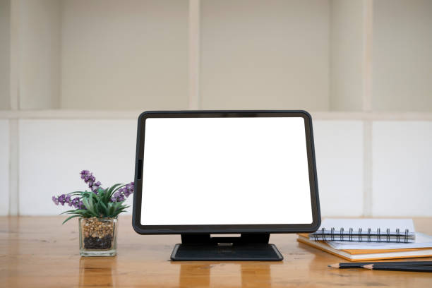 istock Computer tablet, houseplant and notebooks on wooden desk. 1320437895