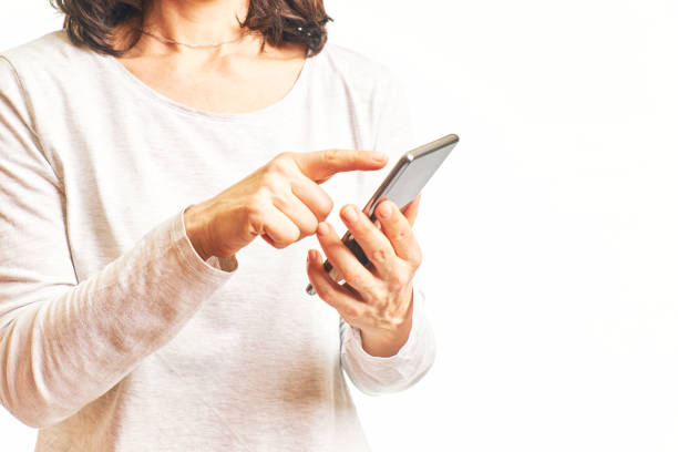 istock Woman looking for wifi with her cell phone on a white background. Technology concept 1320438606