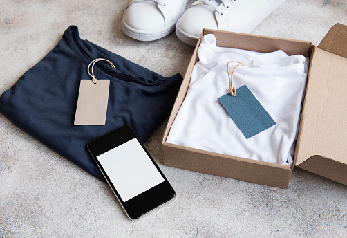 Clothes in an open cardboard box. Online shopping concept. Delivery of clothes.