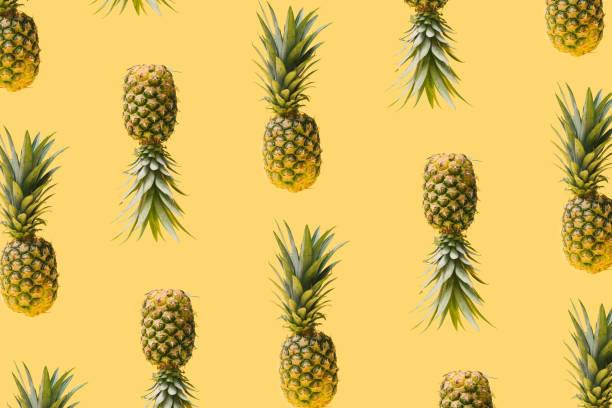 istock Pattern made of many modern, creative fresh exotic funky pineapples against illuminated yellow background. Levitating natural organic ananas summery concept. 1320442716