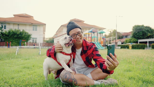 Asian man was taking selfie with his dog on holiday at public park.