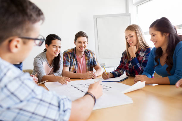 istock group of smiling students with blueprint 1320444936