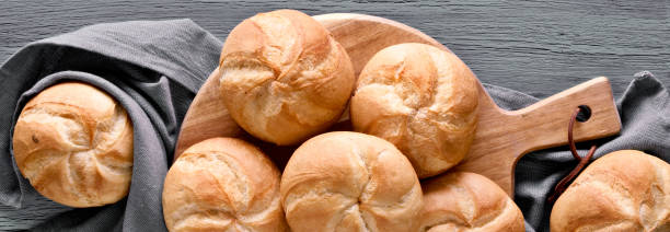 istock Kaiser or Vienna rolls on linen towel, flat lay on grey rustic wood 1320445885