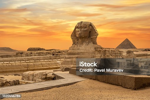 istock Landscape with Egyptian pyramids, Great Sphinx and silhouettes Ancient symbols and landmarks of Egypt for your travel concept to Africa in golden sunlight. 1320446784