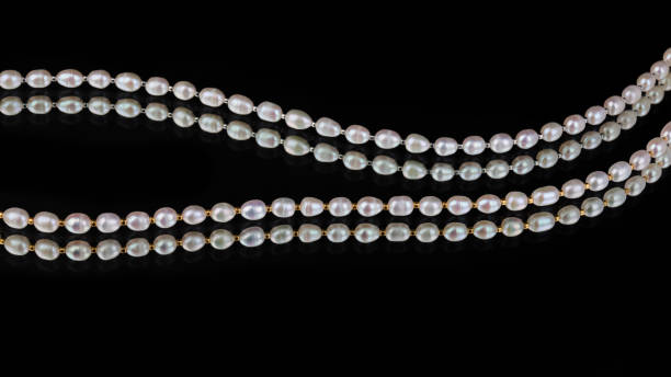 istock Lines of baroque pearls on black mirror background 1320446882