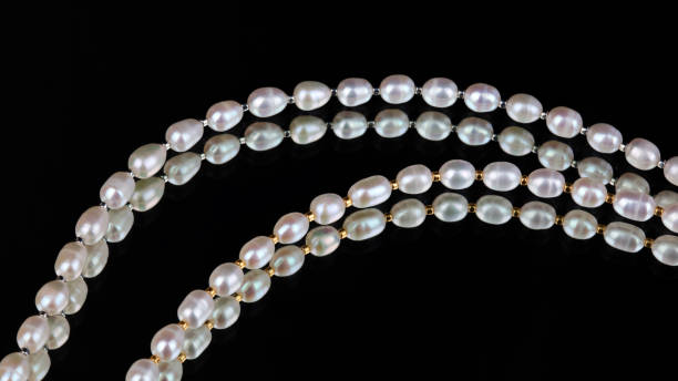 istock Lines of baroque pearls on black mirror background 1320446887
