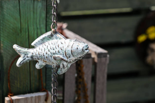 Metal fish on the rain chain in a garden in Yokohama, Japan