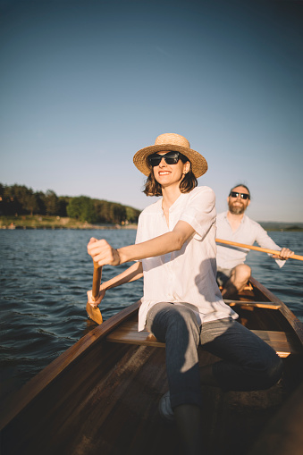 Young copuple enjoy summer canoe ride on the lake.