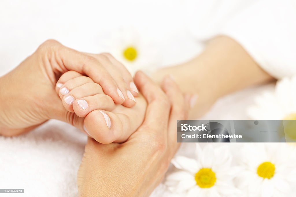 Foot massage Female hands giving massage to soft bare foot Alternative Therapy Stock Photo