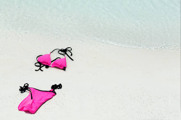 istock Swimsuit lying on white sand close to sea 1320455169