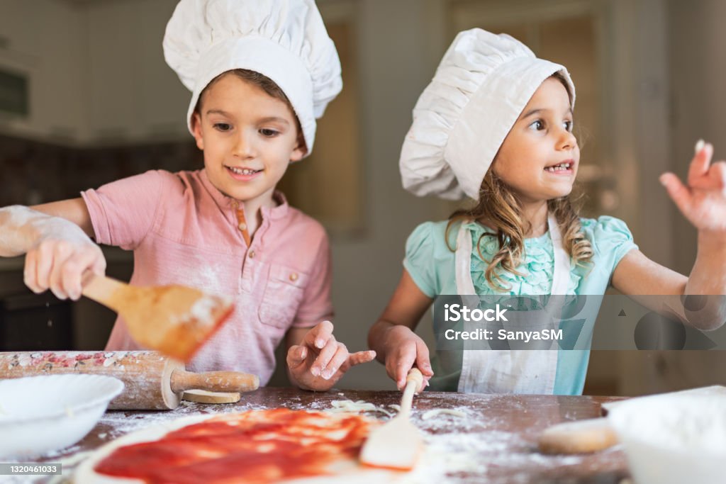 Food preparation at home Toddler boy and girl are preparing food in kitchen. Child Stock Photo