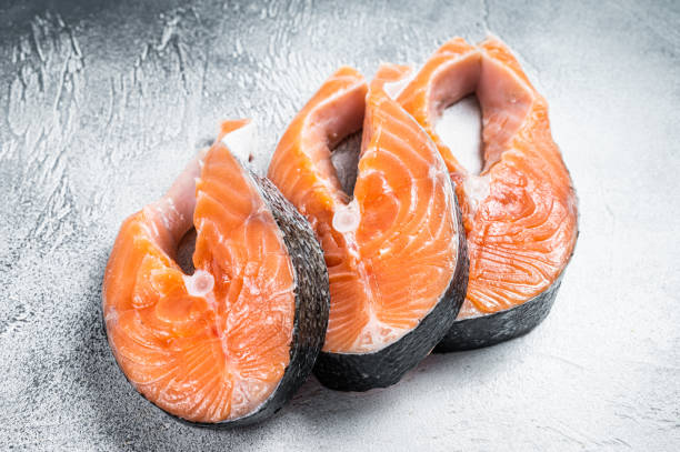 istock Salmon or trout steaks, raw fish prepared for cooking. White background. Top view 1320463624