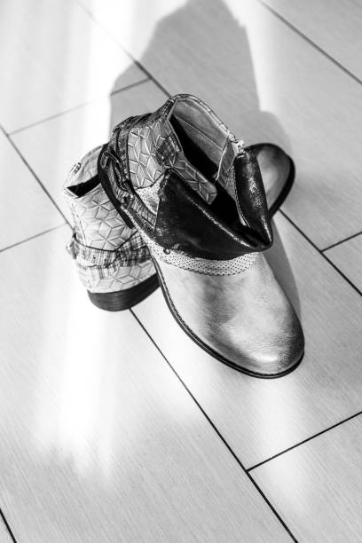 istock Stylish ankle boots with low heels on parquet floor in room 1320468859