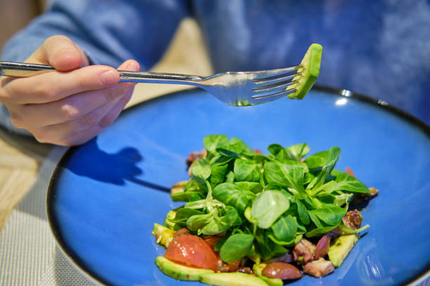 istock A man eats a salad with spinach and avocado at a seafood restaurant. Dinner at the fish cafe 1320469063