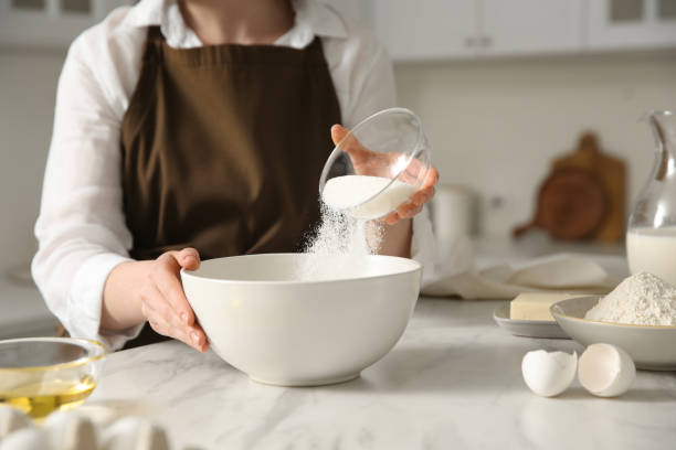 istock Woman making dough at table in kitchen, closeup 1320469323