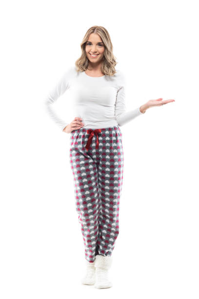istock Happy cute young woman in pajama showing empty space with open hand 1320469373