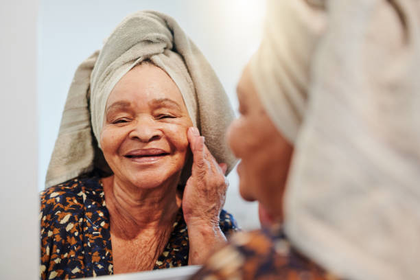 Shot of a mature woman applying her skincare in the bathroom I love feeling moisturised home pampering stock pictures, royalty-free photos & images