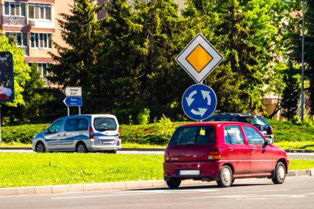 Roundabout with multiple road signs - Center, Sofia, Bulgaria, priority sign and roundabout sign, part of car. The photo is taken in Burgas, Bulgaria at roundabout with Sony A S3 camera.
