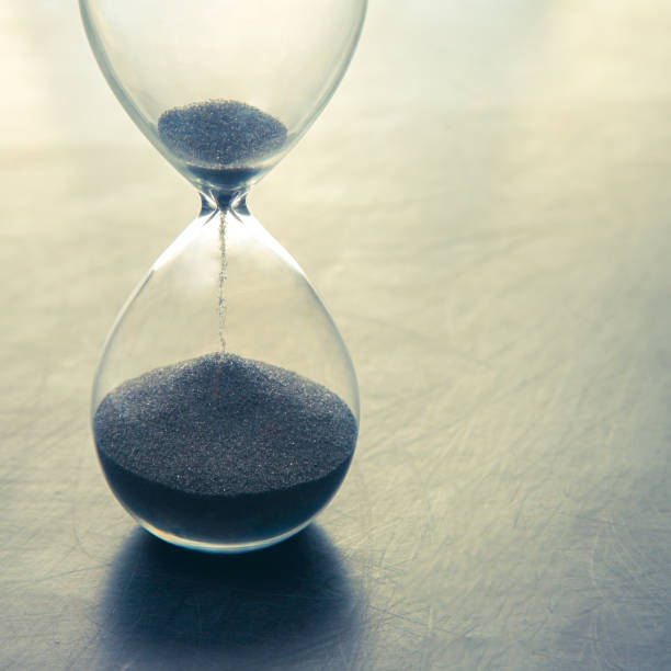 istock Hourglass on a light background. Time is money. Business solutions in time. 1320475259