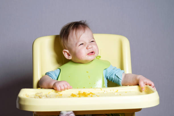 istock little child eats on gray background, child testing food, funny face 1320480124