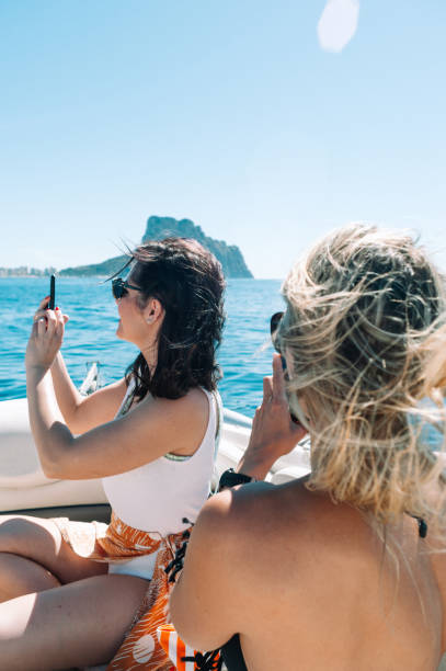 istock Girls using phone on boat at the mediterranean sea 1320480137