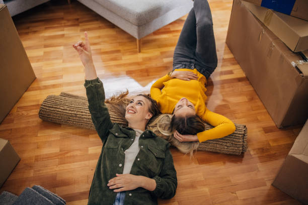 lesbian couple lying on the floor in new home - couple loving lying on back carpet imagens e fotografias de stock