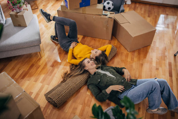 lesbian couple lying on the floor in new home - couple loving lying on back carpet imagens e fotografias de stock