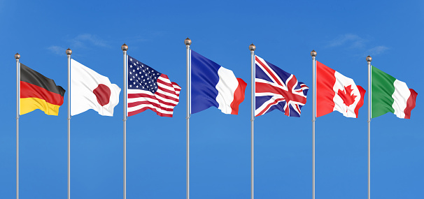 Silk waving G7 flags of countries of Group of Seven Canada, Germany, Italy, France, Japan, USA states, United Kingdom. Blue sky background. Big G7 in France 2019. 3D illustration.