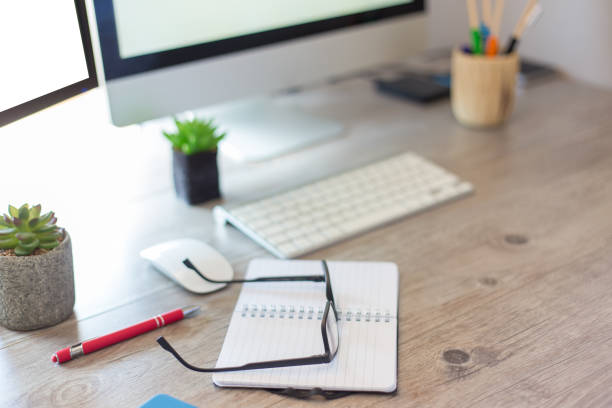istock Latino man working in front of the computer taking notes in his agenda 1320483297