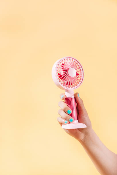 istock unknown person holding an electric fan. vertical image 1320483586