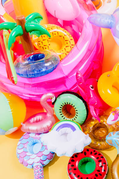 istock many pool inflatables of different shapes and colors on a yellow background. vertical image 1320483588