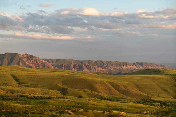 istock Beautiful summer landscape, panoramic green field and. mountains after sunset. 1320485430
