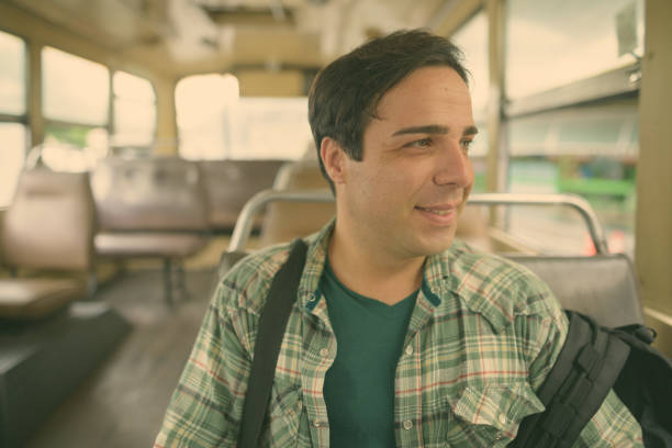 istock Portrait Of Young Man Looking Away While Sitting In Bus 1320485869