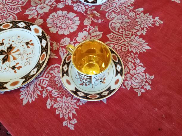 istock gold and black and white cup and plates on table 1320487363