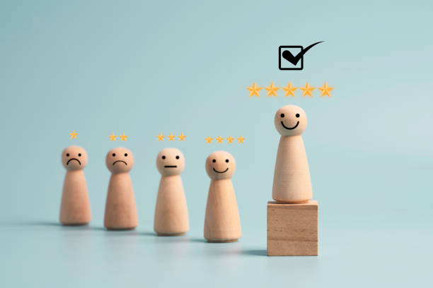 istock Wooden figure smiley with five yellow stars and standing on cube for select the best client and customer evaluation concept. 1320489899