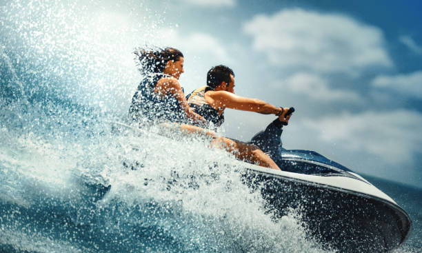 young couple jet skiing. - motorboat nautical vessel speedboat speed imagens e fotografias de stock