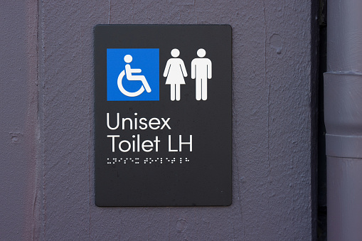 . Sign on a wall for a handicapped toilet.