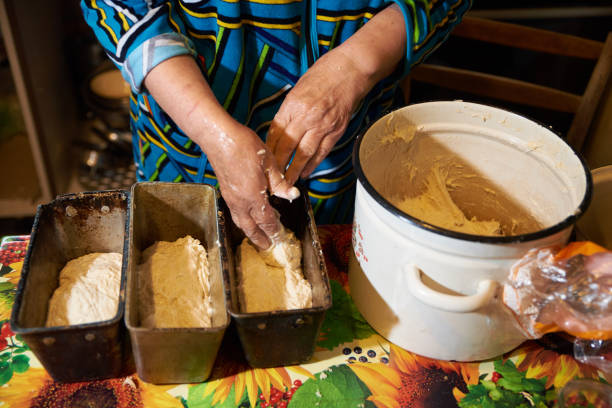 istock Grandmother lays out the dough in forms for baking bread at home 1320494380