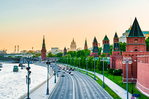 Sunset in Moscow - view to The Kremlin from Bolshoy Moskvoretsky Bridge. The river Moscow is on the left, cloudless sky is on the background.
