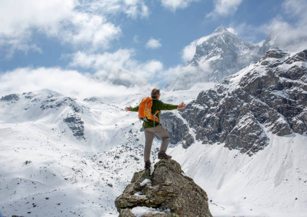 istock Hiker stands on mountain peak with arms outstretched 1320497095