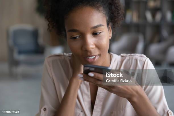 Young African Woman Dictating Audio Message On Cellphone Stock Photo - Download Image Now